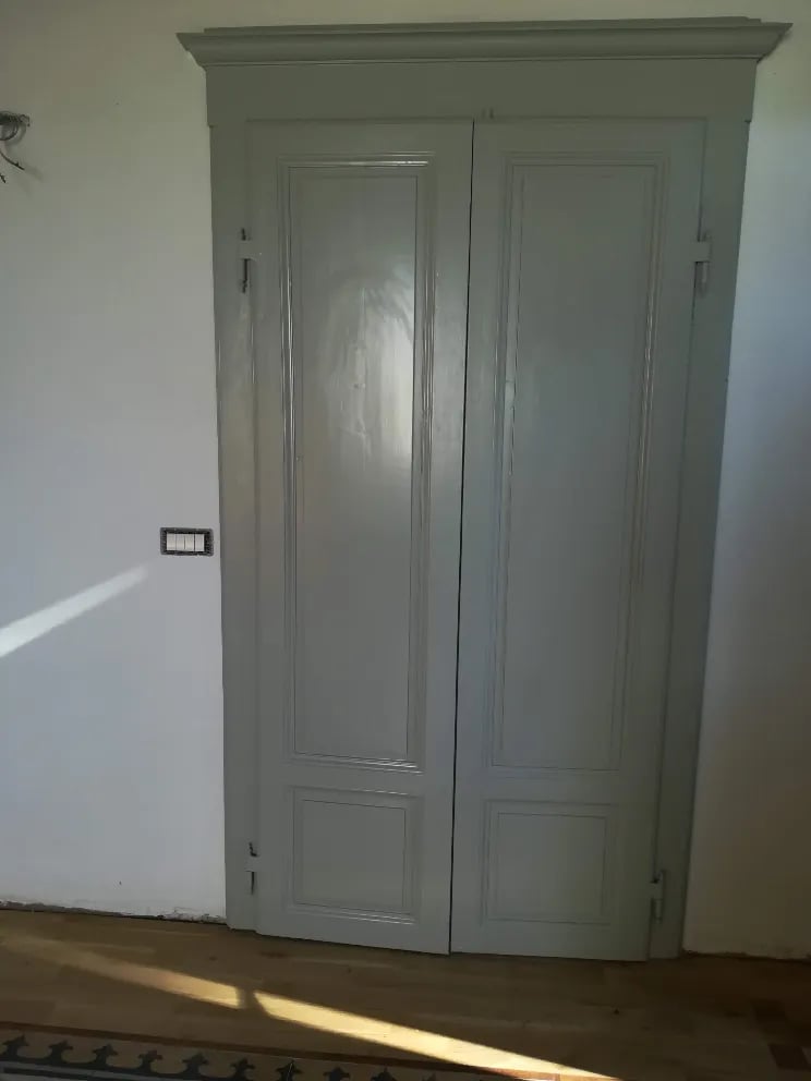 brown wooden door on white concrete wall